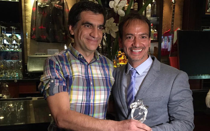 President of Mr. Gay World Eric Butter (r) presents his Philanthropy Award to Juan Carlos Alonso (Mr Gay World)