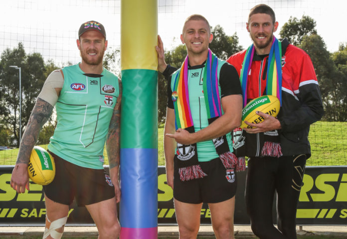 Saints players Tim Membrey, Seb Ross and Tom hickey (L-R) with te custom rainbow goal wraps to be used at the pride match this weekend.(Supplied)