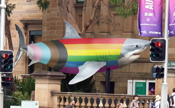 Jurassic Lounge Goes Rainbow With Pride Edition For Sydney Worldpride A Jurassic shark dressed in the progress flag outside the Australian Museum (Supplied)